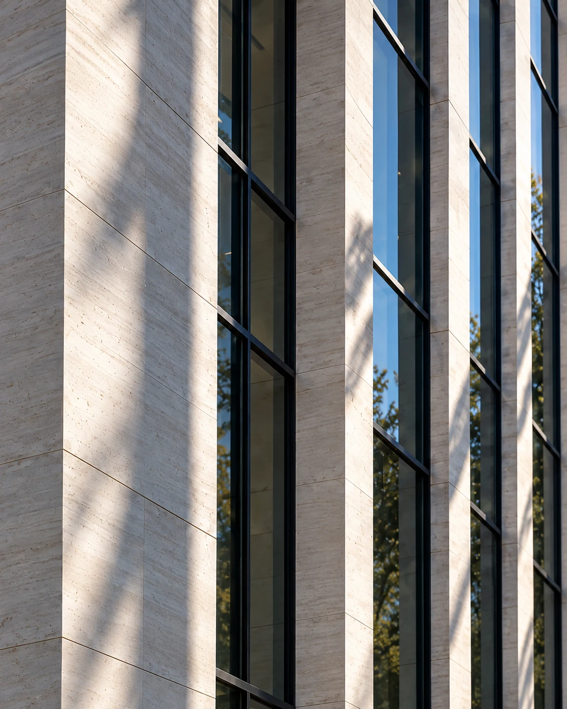 Sunlight across limestone piers and glass windows